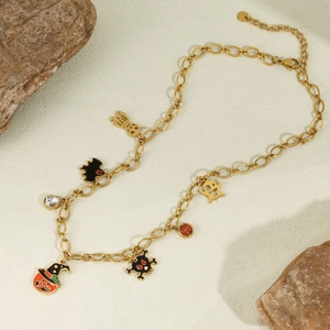 Collier d'Halloween avec breloques dorées de citrouille, fantôme et chauve-souris sur texture