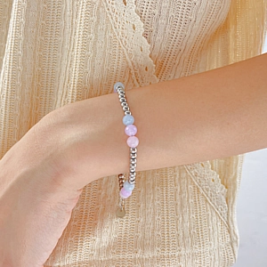 Detail of beaded bracelet with pink natural stones and silver beads on a wrist