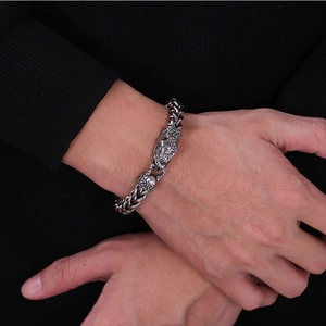 Detailed close-up of a stainless steel dragon bracelet with blue zircon eyes on a male wrist