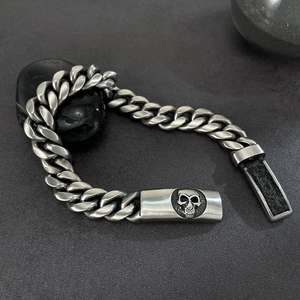 Detailaufnahme der antik-silbernen Totenkopf-Platte an schwerer Gliederkette