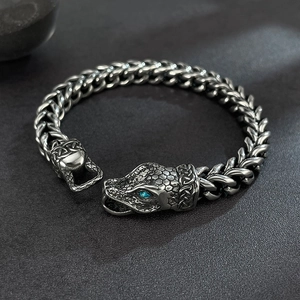 Detail of vintage snake head bracelet with blue stone eyes and textured metal scales