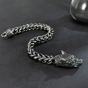 Detail of vintage silver wolf head bracelet with blue stone eyes and wheat chain link