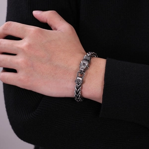 Close-up of a snake head clasp on a wheat chain bracelet with vintage metal finish