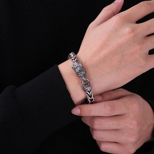 Macro detail of men's gothic wolf head bracelet with blue stone eyes and silver chain