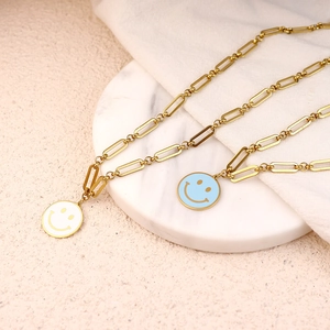 Gold paperclip chain necklace featuring white and blue enamel smiley face pendants