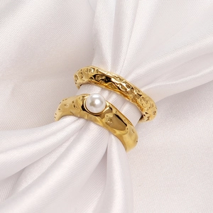 Set of two gold stainless steel rings with irregular hammered texture and white pearl