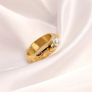 Detail of hammered gold stainless steel ring featuring a lustrous white freshwater pearl