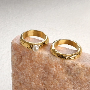 Detail of hammered stainless steel ring with freshwater pearl on pink rock