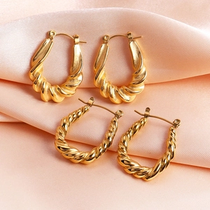 Elegant gold twisted rope earrings in thick and thin styles on silk background