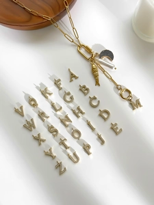 Detailopname van gouden letterhangers met kristallen en elegante parelversieringen