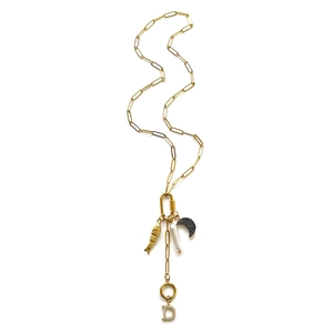 Detail van gouden paperclip ketting met parel, vis en hanger met diamantletter D