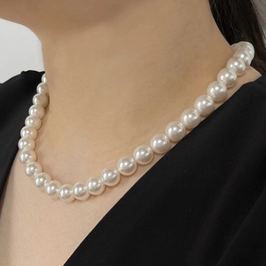 Elegant white pearl necklace featuring round glossy pearls worn by a female model
