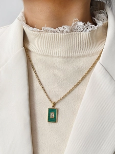 Detailopname van een gouden Figaro-ketting in INS-stijl met groene malachiet hanger
