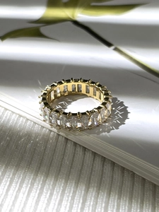 Makroaufnahme Goldring mit Zirkonia im Smaragdschliff und natürlichem Blätterschatten