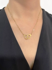 Close-up of 18K gold double interlocking handcuff pendant necklace on model's neck