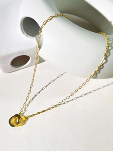 Detail of 18K gold plated paperclip chain necklace with interlocking handcuff pendants