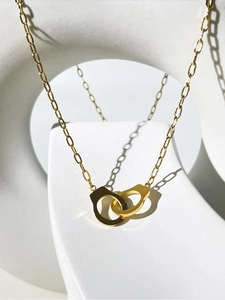Detailed view of the 18K gold-plated double-loop handcuff pendant and interlocking chain