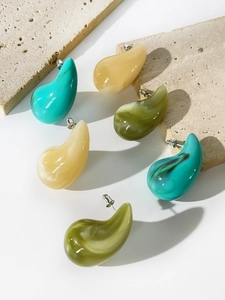 Close-up of teardrop acrylic stud earrings with marble texture in green and beige