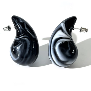 Macro detail of acrylic drop earrings featuring black and white ink marble texture