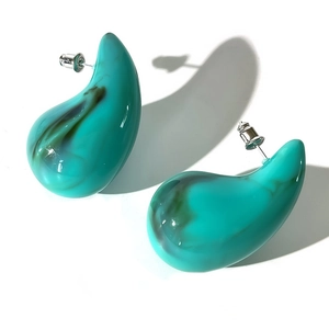Macro detail of turquoise acrylic teardrop earring with dark marble texture and metal stud