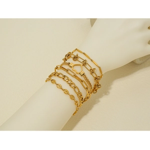 Détail d'un ensemble de 6 bracelets en acier inoxydable doré sur un poignet