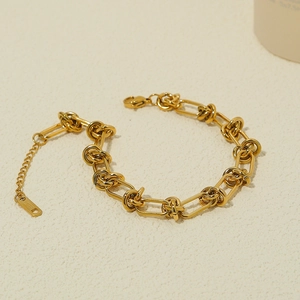Détail du bracelet chaîne dorée avec anneaux à bascule, fermoir homard et étiquette en acier