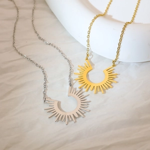 Détail du collier avec pendentif en forme de rayons de soleil dorés et argentés