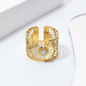 Anillo abierto dorado con patrón radial calado y piedra de nácar blanca en soporte