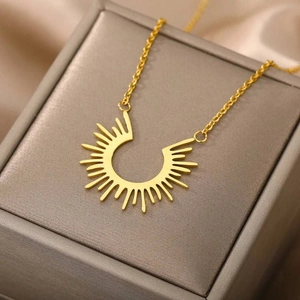 Collier minimaliste en acier titane doré avec pendentif soleil sur boîte à bijoux