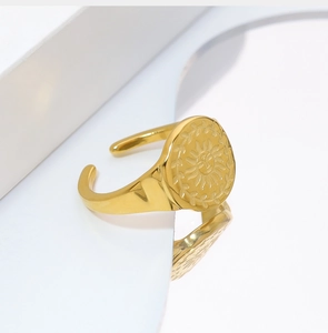 Close-up van gouden zegelring met zonnebloempatroon en vintage gravering met spiegelreflectie