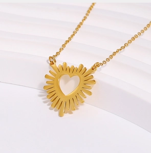 Macro detail of golden heart necklace with radiant sunburst texture on white stand