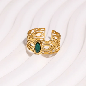 Detail van vintage goudkleurige ring met groene steen en verstelbare open band