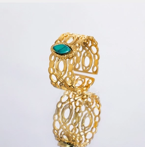 Detailopname van vintage goudkleurige ring met groene malachiet en geometrisch opengewerkt patroon