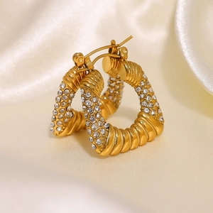 Pendientes de titanio chapados en oro con circonitas y diseño de giro clásico