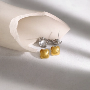 Minimalistische klaveroorstekers in goud en zilver met matte geborstelde textuur