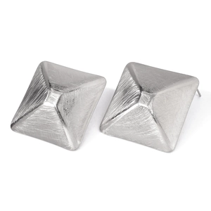Macro detail van geometrische piramide oorknopjes met een geborstelde metalen afwerking