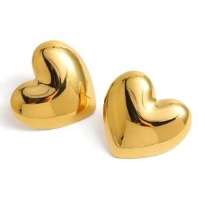 Detail van grote gouden hartvormige oorbellen met een gepolijste spiegelafwerking
