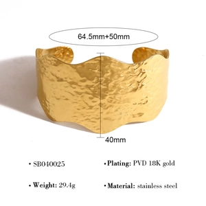 Macro-opname van een 40mm brede gehamerde gouden roestvrijstalen manchet met 18K vergulding