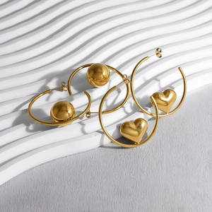 Polished gold stainless steel hoop earrings featuring heart and sphere pendants