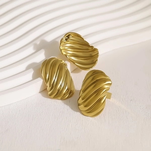 Set orecchini e anello a croissant a coste in oro opaco su sfondo bianco strutturato
