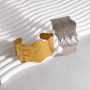 Brede roestvrijstalen armbanden met gehamerde textuur in goud en zilver met golfring
