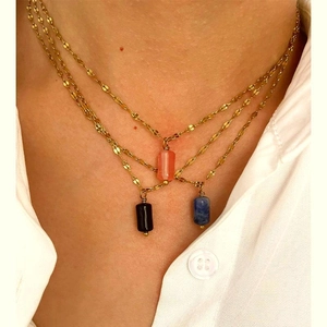 Close-up of layered stainless steel gold chains with colorful natural stone pendants