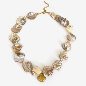 Irregular shell necklace with a golden scallop pendant on a minimalist white background