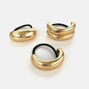 Set di tre elastici per capelli in metallo dorato con forme geometriche e lacci neri elastici
