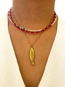 Detalle de un collar de capas con colgante de pez y cuentas acrílicas rojas y blancas en modelo
