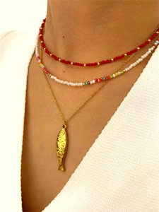 Detalle de collar de acero inoxidable con cuentas acrílicas y colgante de pez dorado