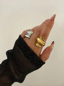 Detail showing two chunky stainless steel wave rings in gold and silver finish on hand