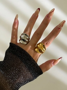 Detail of gold and silver chunky wave rings with a high-shine melted metal texture