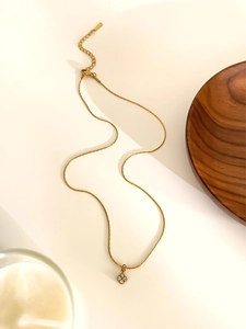 Detail of a gold stainless steel necklace featuring a four-petal flower zircon pendant