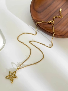 Detail of gold star pendant with white rhinestones on a stainless steel beaded chain